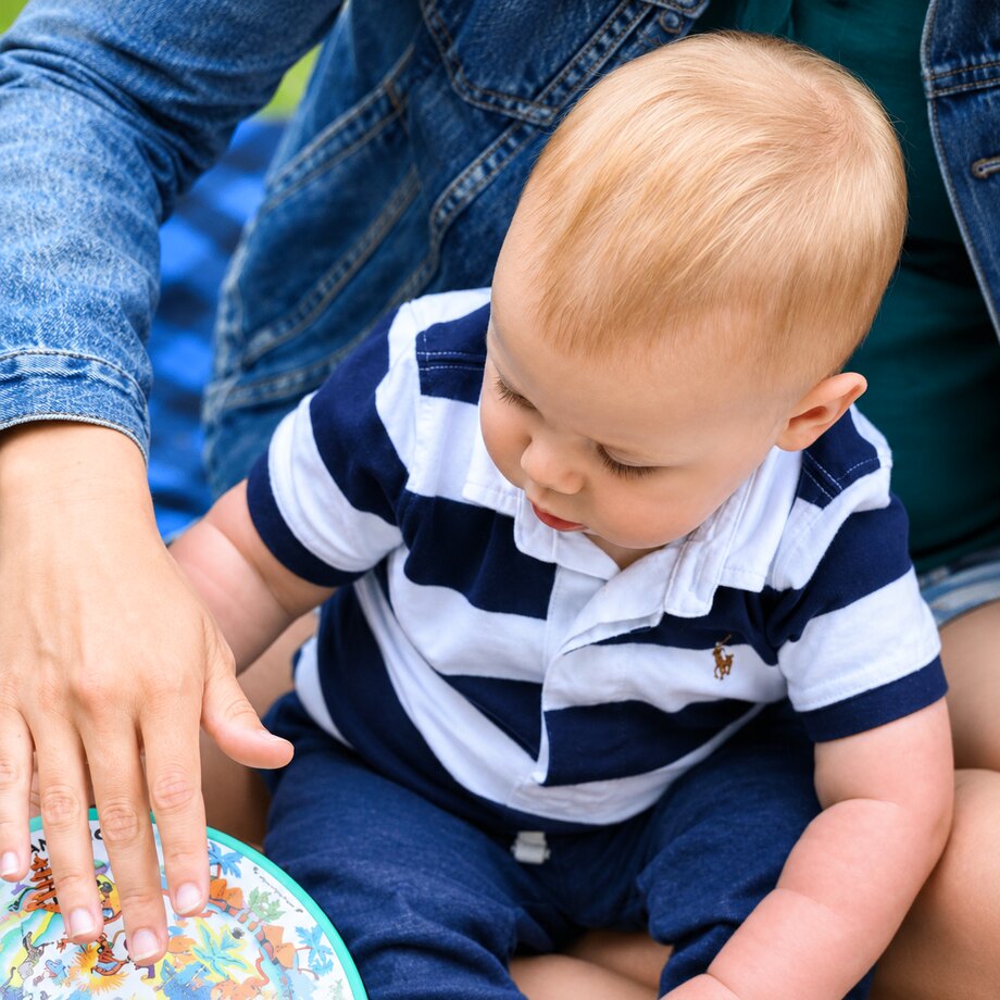 A parent and baby exploring a drum together at a Songbirds Music class